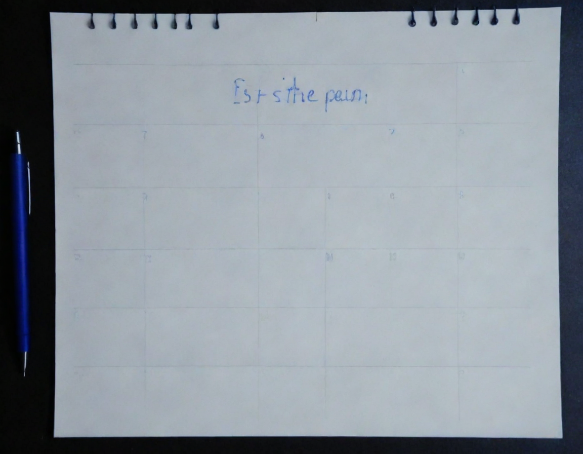 A calendar and a pen on a dark desk